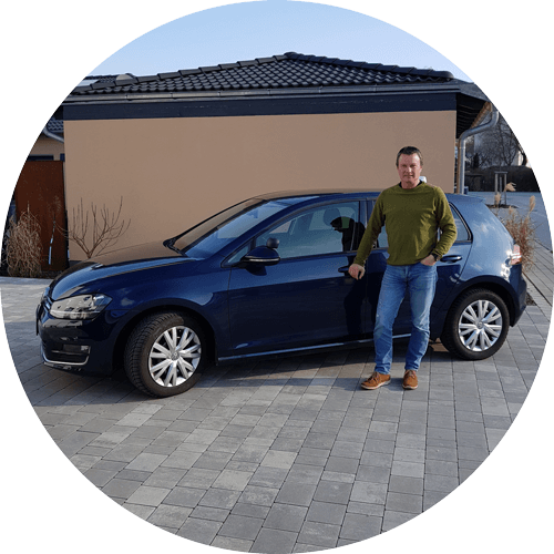 Herr Samhuber steht vor dunkelblauen VW Golf